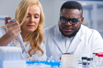 Professional team of scientists is working on a vaccine in a modern scientific research laboratory. Genetic engineer workplace. Future technology and science.