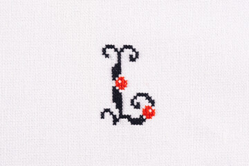 Letter L of Embroidered Cross - Stitch Latin Alphabet on White Linen Fabric Handmade Close-up