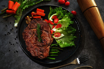 Beef Steaks in a Hot Plate on a Dark Floor
