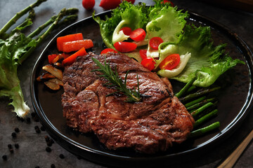 Beef Steaks in a Hot Plate on a Dark Floor