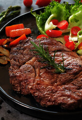Beef Steaks in a Hot Plate on a Dark Floor