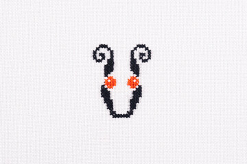 Letter U of Embroidered Cross - Stitch Latin Alphabet on White Linen Fabric Handmade Close-up