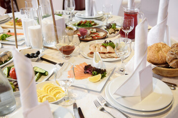 Table setting with sparkling wineglasses, plate with white napkin and cutlery on table, copy space. Place set at wedding reception. Table served for wedding banquet in restaurant