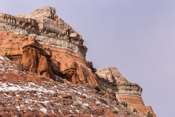 Fototapeta premium Changing colors of geological formations on mountain with patches of snow in rural New Mexico