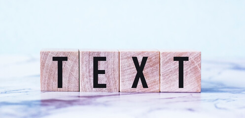 The word TEXT is written on wooden blocks and a light background