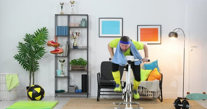 Cycling in look back actions, funny crazy cyclist riding exercise bike at home looks back