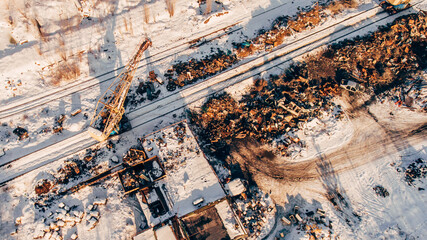 Aerial photography of scrap metal dump, Crane unloads, loads scrap metal in a railway car.