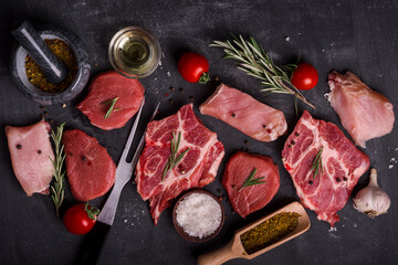 Set of various  raw meat on wooden cutting board at kitchen table