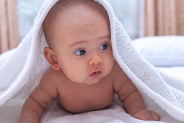 A baby with a white towel on his head.