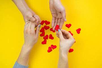 Hands on a yellow background with a heart, love. Selective focus.