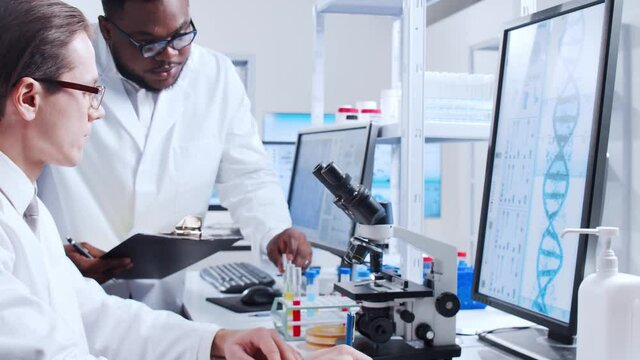 Professional team of scientists is working on a vaccine in a modern scientific research laboratory. Genetic engineer workplace. Futuristic technology and science concept.