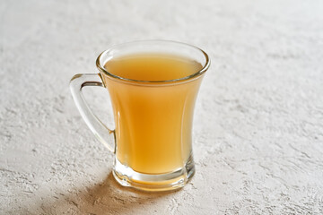 A single cup of beef bone broth on a white background