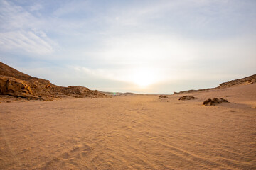 Fototapeta na wymiar sand dunes and stones in the desert of Egypt at sunset with blue sky