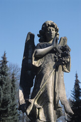 Steinerne Engelsfigur auf einem Grabstein