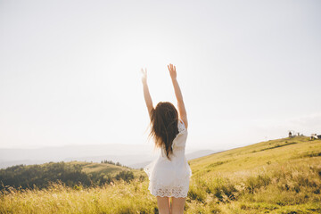 Fototapeta premium Attractive girl having fun outside nature background mountains happy emotions smiling moving hands turning around long hair have rest vacation Summer.