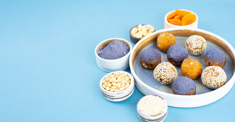 Obraz na płótnie Canvas Homemade blue matcha butterfly pea tea powder energy balls in a ceramic bowl on a top view background, healthy sweets made of nuts, dry apricots. Concept vegeterian diet sweet brain food Copy space