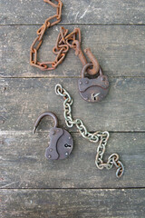Steampunk style two old rusty padlock and rusty chain on wooden background. High quality photo