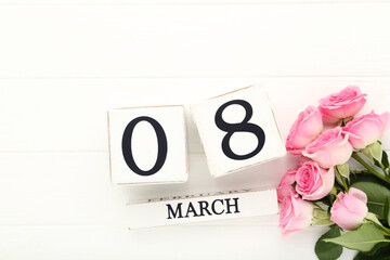 Wooden calendar with pink roses on white background