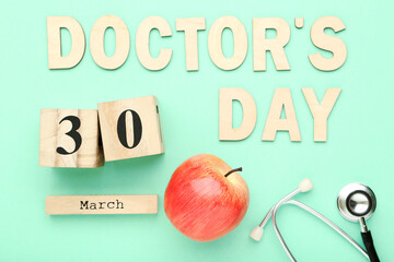 Text Doctor's Day with stethoscope, red apple and cube calendar on mint background
