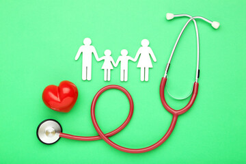 Stethoscope with red heart and family figure on green background