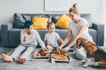 Family spending time together and eating pizza at home.