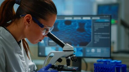 Portrait of scientist looking under microscope in medical development laboratory, analyzing petri dish sample. Medicine, biotechnology research in advanced pharma lab, examining virus evolution