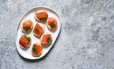 Bread toast with butter and salmon for a snack. Breakfast. Fish canapes on the table.