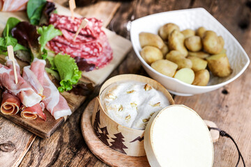 Fromage chaud Mont d'or ou boite chaude accompagné de charcuterie et pommes de terre (spécialité du Jura, france)