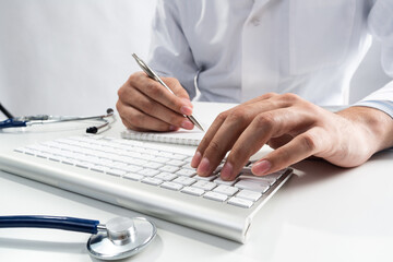 Doctor typing on wireless computer keyboard