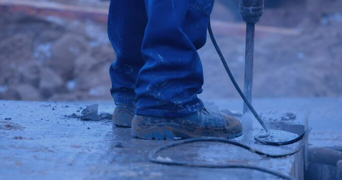 A builder cuts a groove in a concrete slab with a large industrial perforator