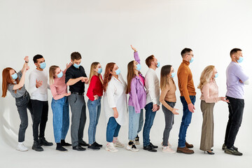 Obraz premium people waiting in line practising social distancing at city shop, in queue. new normal lifestyle concept with people wearing face mask on urban queue, people stand outraged. isolated studio shoot