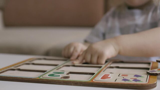 Little girl playing puzzel with numbers on the table. Figures. Handheld close up shot.