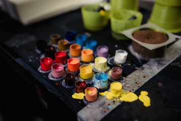 Close-up of tattoo pigment of different colors in boxes into needles