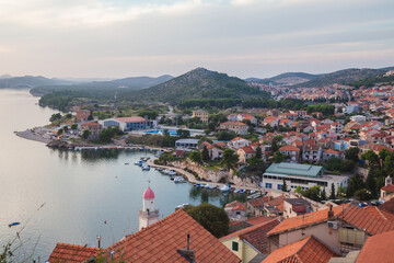 Naklejka na ściany i meble A view of Sibenik on the Adriatic coast in Croatia captured from atop the hillside old town looking to the hills and the sea.