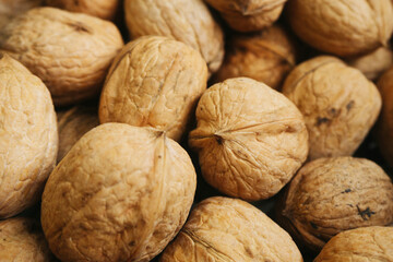 Walnut background. Natural walnuts texture. Nuts in shells. Stacked pile of wallnuts pattern.