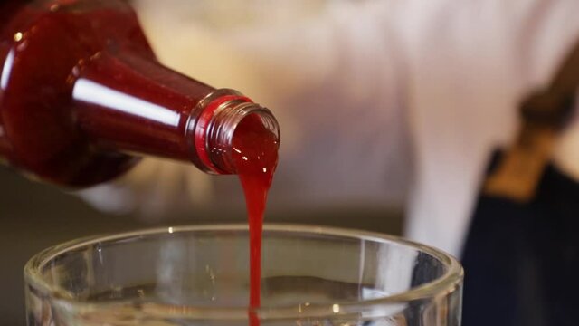 Bartender preparing a cocktail on a bar counter. Making strawberry juice in a glass blender.