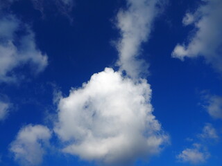 fluffy round clouds in bright blue sky