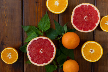 oranges and grapefruit on a brown wooden background, top view, text space, citrus