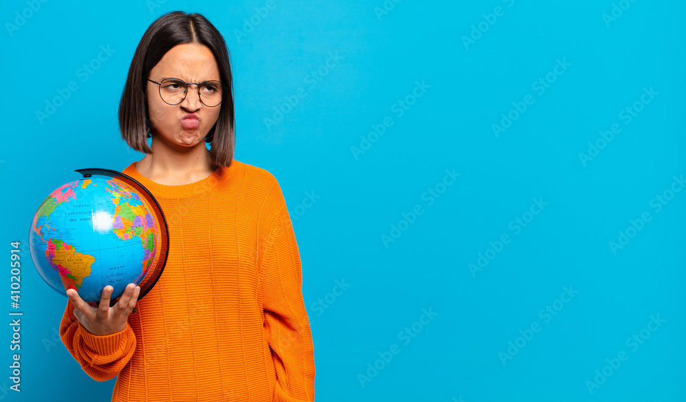 Wall mural young hispanic woman feeling sad, upset or angry and looking to the side with a negative attitude, frowning in disagreement