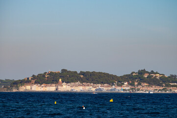 Fototapeta premium Blue water of Gulf of Saint-Tropez with outlines of Saint-Tropez town on background, French Riviera, France