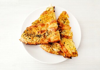 Two slices of pizza on a white background and a white plate.