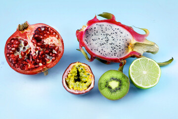 Pomegranate, Dragon Fruit, Passion Fruit, Kiwi and Lime shot on blue background