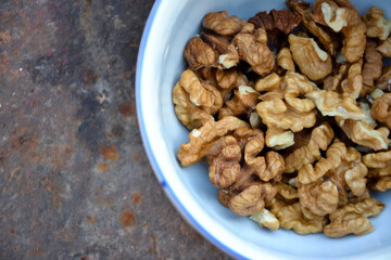 Walnuts harvest on vintage metal background. Walnut kernels from village garden. Organic autumn nuts harvest.