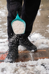 ice melt rock salt is being spread on your walking path to melt the snow and ice