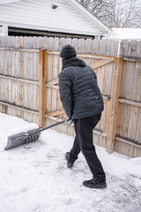 man is shoveling snow from your sidewalk and driveway after a recent snow storm