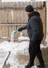 man is spreading salt to melt the ice on your path