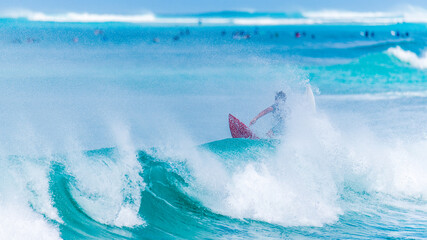 Surfeur sur une planche rouge quittant une vague en train de dérouler dans un brouillard d'embruns sur la mer des Caraïbes à la plage du Souffleur port louis en Guadeloupe  - obrazy, fototapety, plakaty