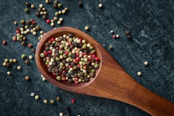 Mixed of peppercorns in a wooden spoon, top view, close up