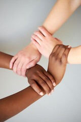 interracial human hands keeping in chains for friendship and love, concept of peace and unity against racism - multi ethnic couple holding hands isolated in studio