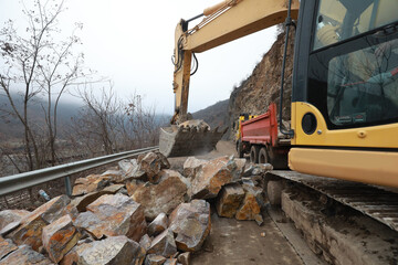 Fototapeta premium Elisseina, Bulgaria - February 2, 2021: Heavy chain and wheeled equipment clears the highway after a rock collapse near Elisseina station, Bulgaria
